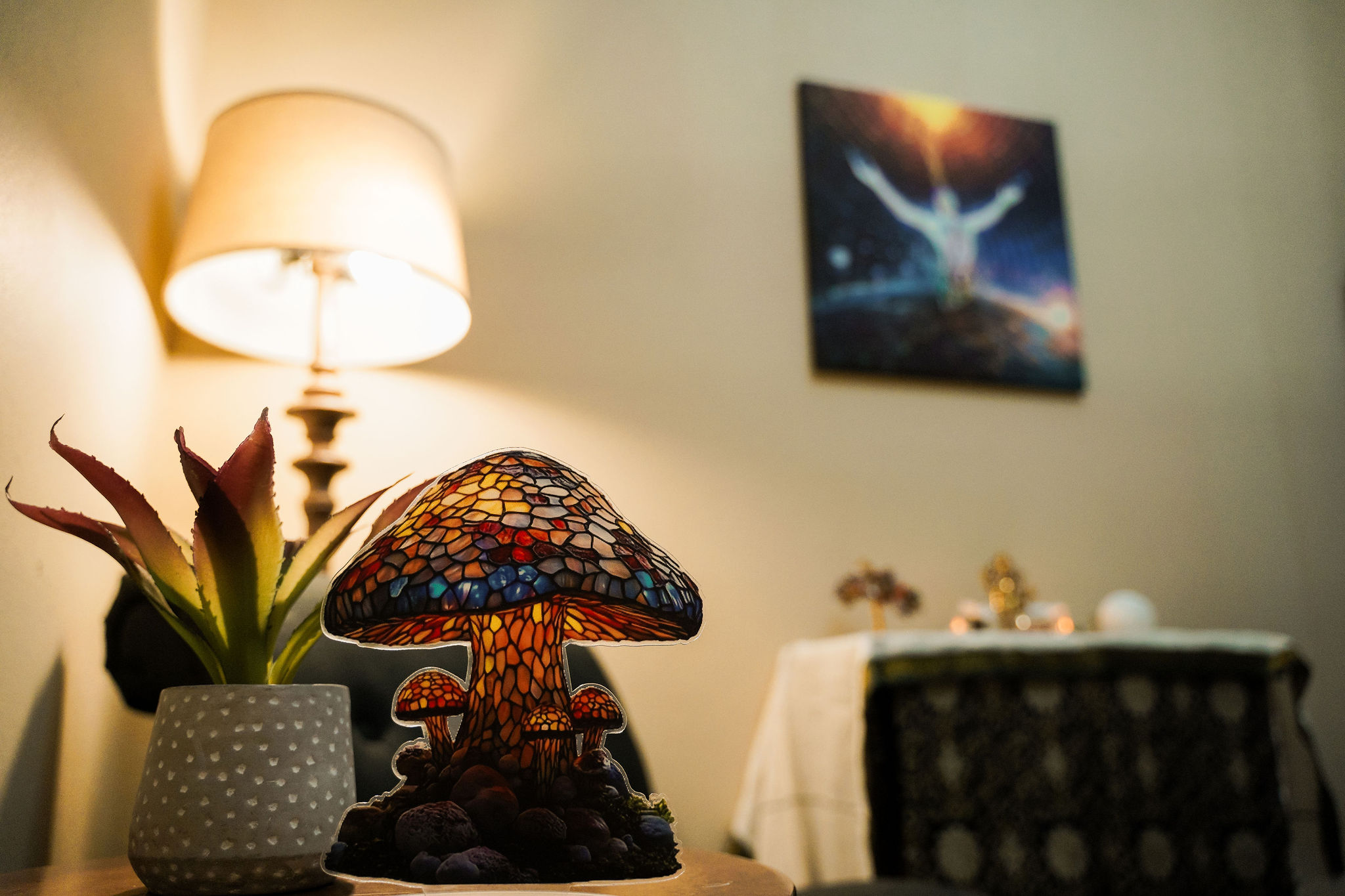 The Ayumind Journey Room — a warmly lit space with a stained-glass mushroom lamp, plant, and spiritual artwork
